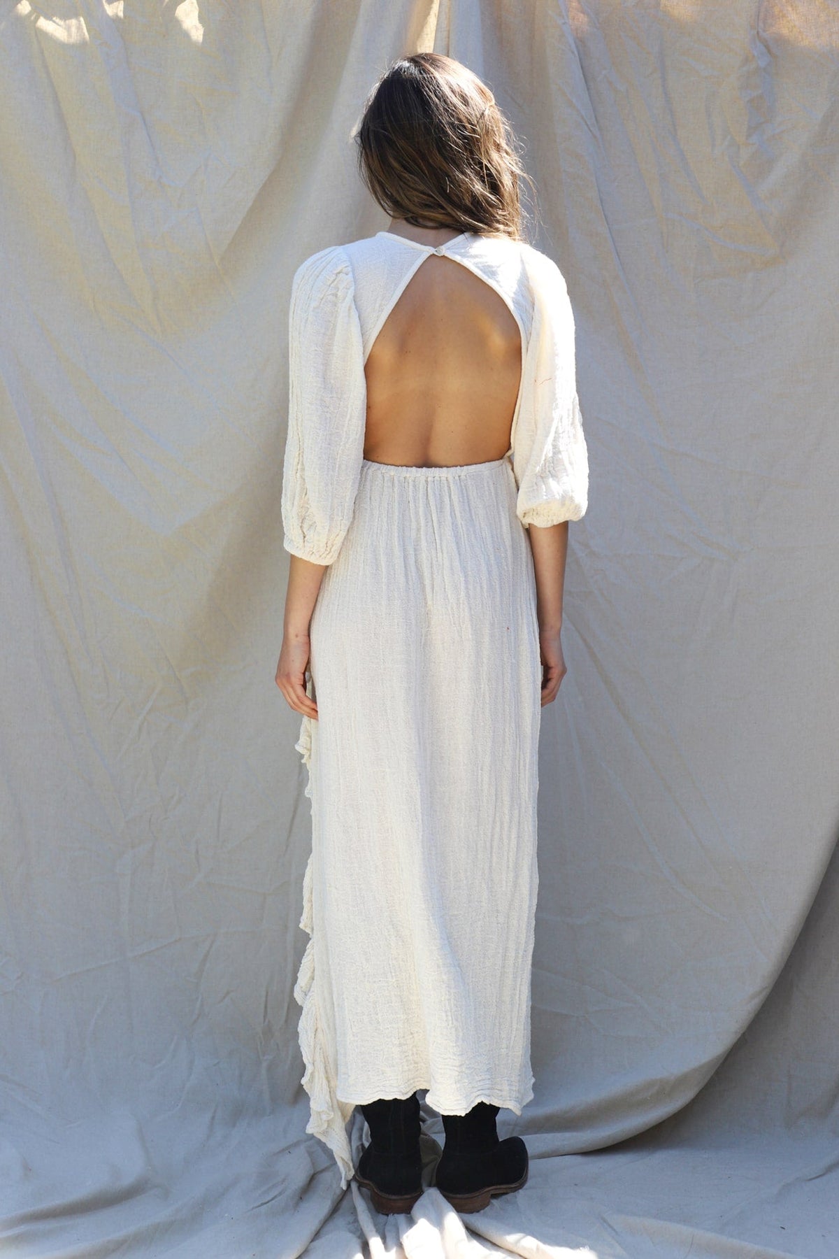 back of dress is open from shoulder to waist with button closure at back of neck