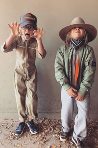 boy on left wearing little palmetto station suit in army green. Boy on right wearing little palmetto station suit in stormy stripe